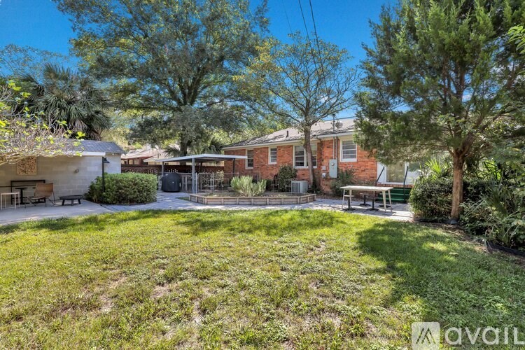 A backyard with a picnic table and a tree.