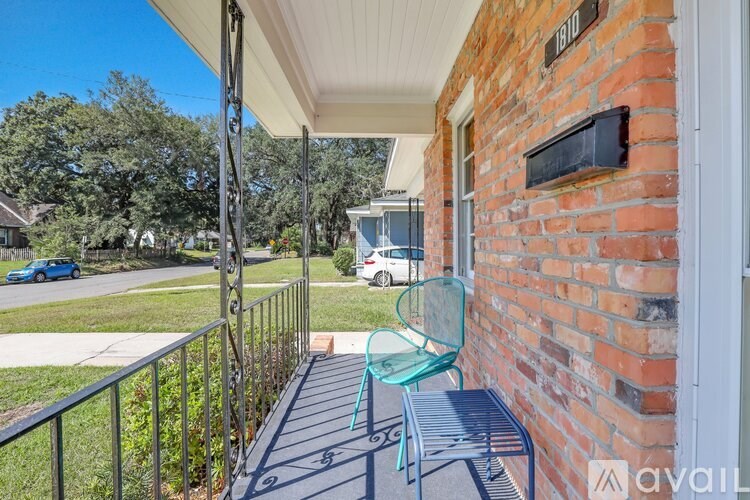 A balcony with a green chair and a brick wall.