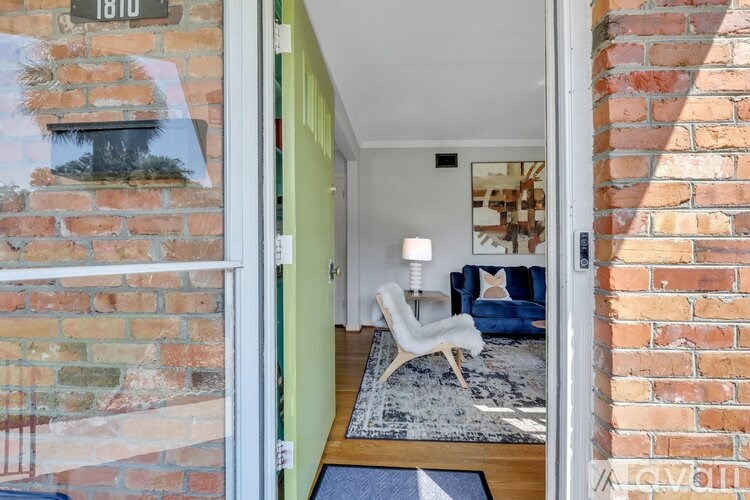 A white chair is in a room with a blue couch.