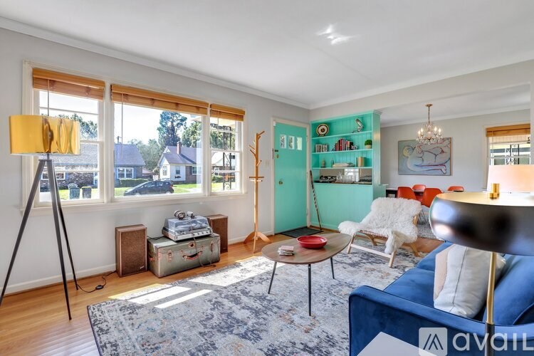 A living room with a blue couch and a large window.