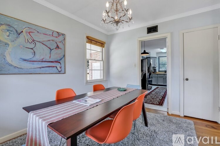 A dining room with a wooden table and orange chairs.