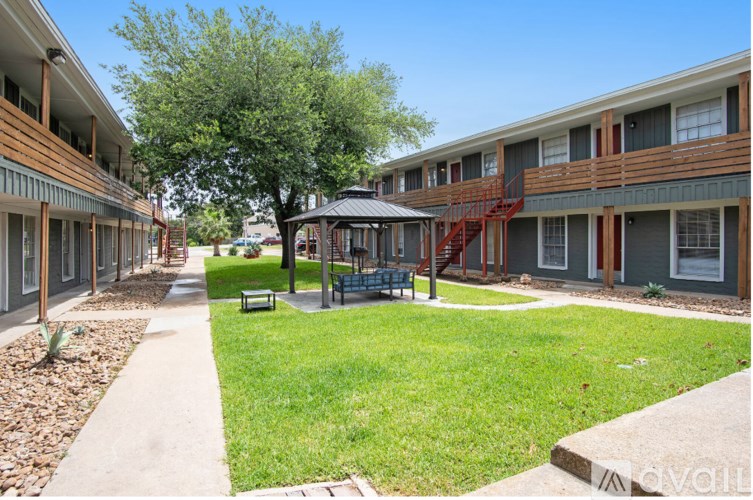 A tree in a grassy area in front of apartment buildings.