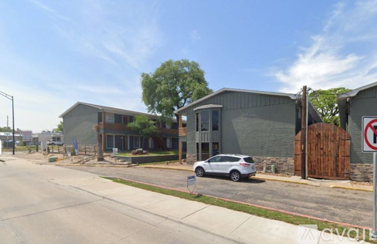 A street view of a building with a car parked in front.