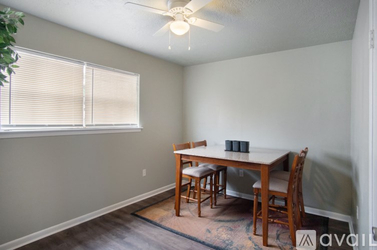 A dining room with a table and chairs.