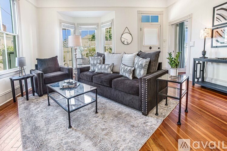 A living room with a grey sofa and a glass coffee table.