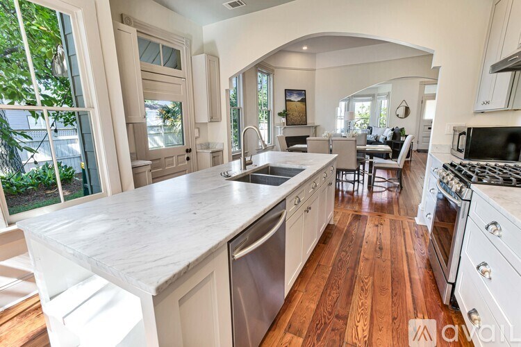 A kitchen with a marble countertop and wooden floors.