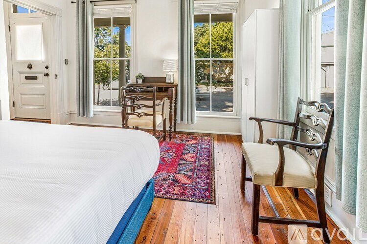 A bedroom with a bed, chair, and desk.