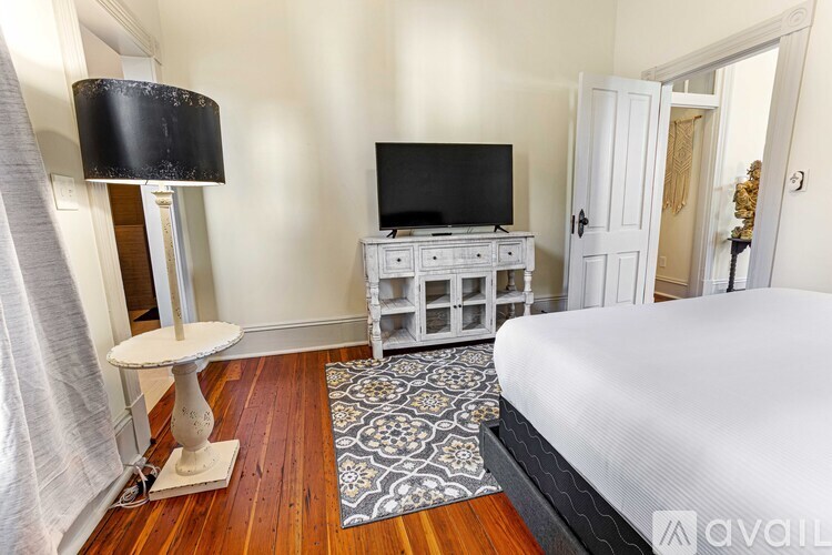 A bedroom with a bed, a television, and a dresser.