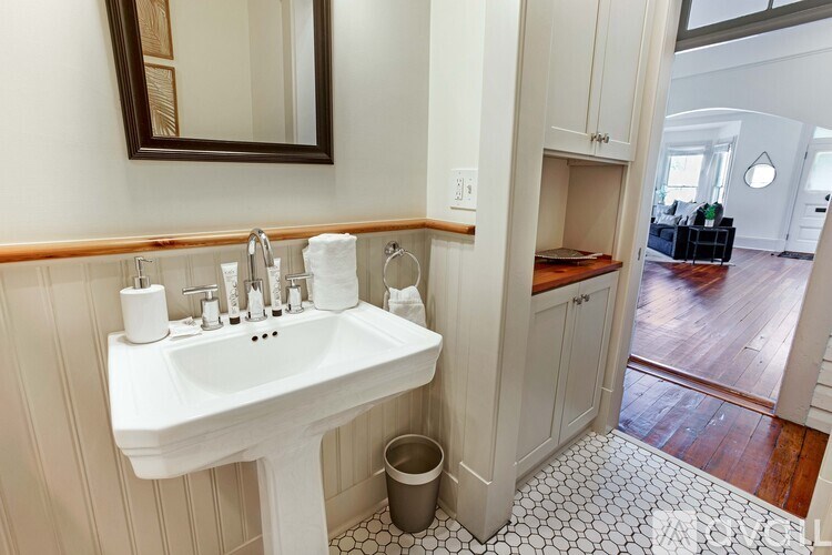 A bathroom with a white sink and a mirror.