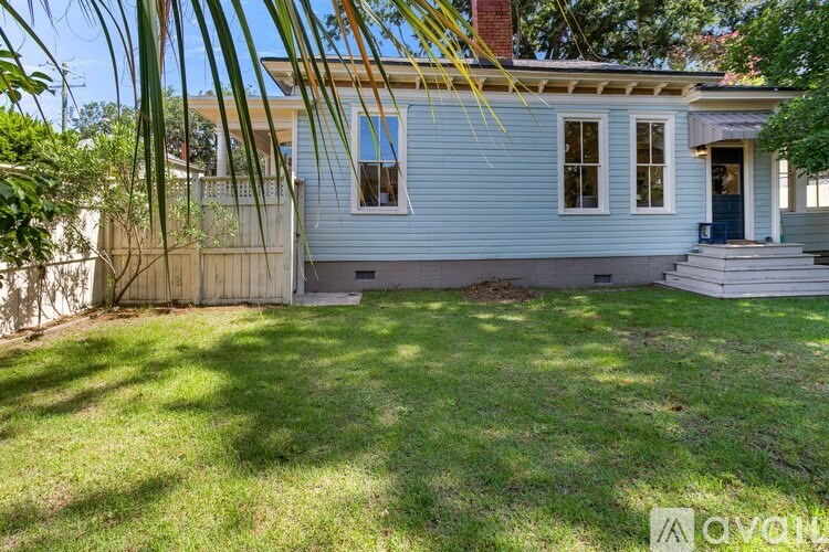 A house with a blue front and a white fence.