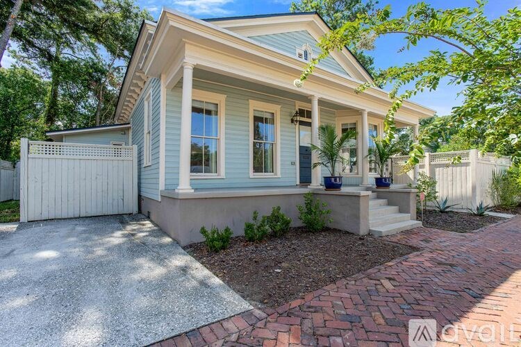 A house with a blue front and a white fence.