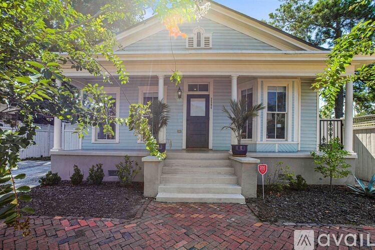 A house with a front yard and a "for sale" sign.