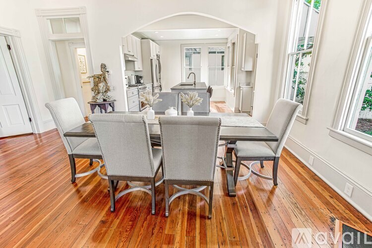 A dining room with a wooden floor and a table set for four.