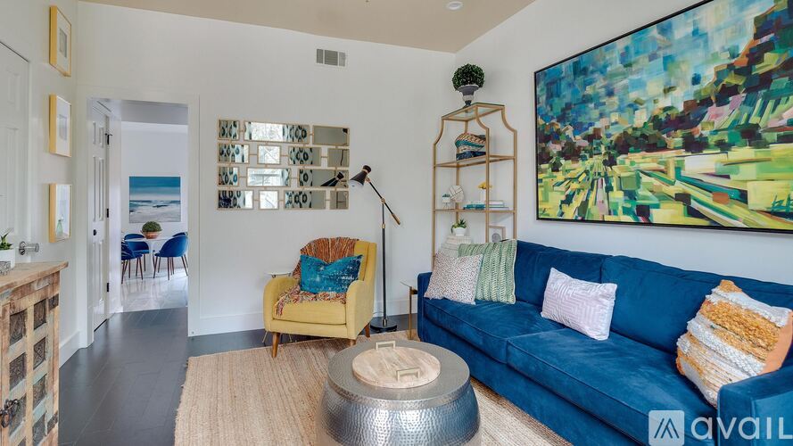 A living room with a blue couch and a yellow chair.