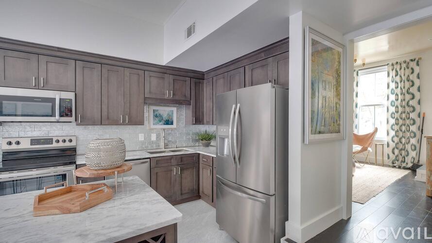 A kitchen with a refrigerator, oven, and microwave.