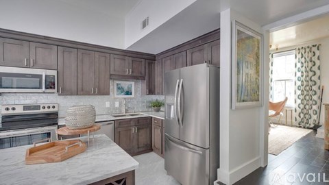 A kitchen with a refrigerator, oven, and microwave.
