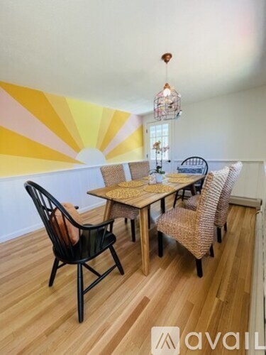 A dining room with a wooden table and chairs.