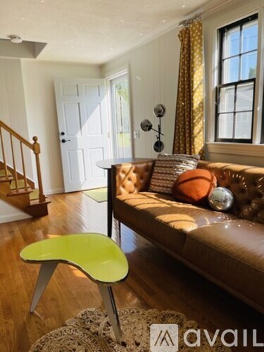 A living room with a brown couch and a green chair.