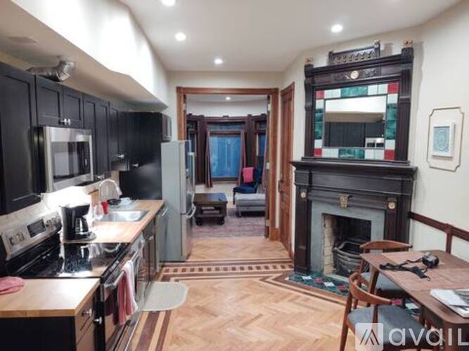 A kitchen with a black fridge and a wooden table.