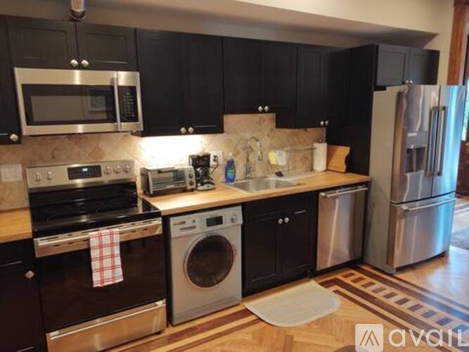 A kitchen with black cabinets and stainless steel appliances.