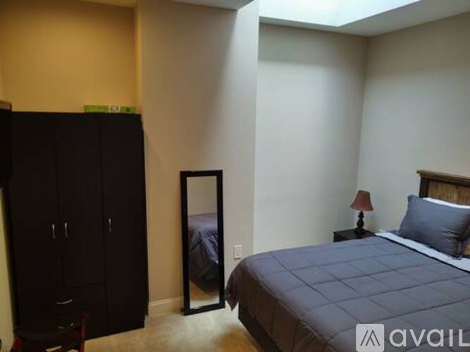 A bedroom with a bed, a wardrobe and a nightstand.