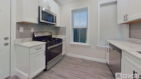 A kitchen with white cabinets and a microwave above the stove.