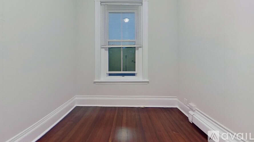 A room with a window and wooden floors.