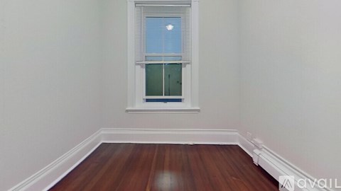 A room with a window and wooden floors.