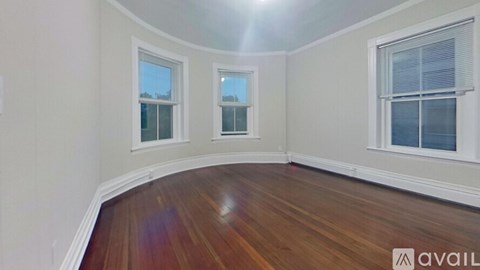 A room with wooden floors and two windows.