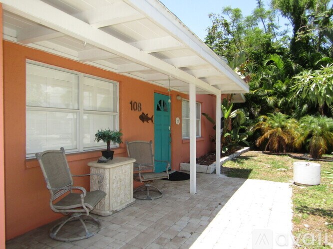 A small orange house with a porch and a door.