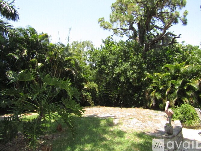A lush green garden with a statue in the middle.