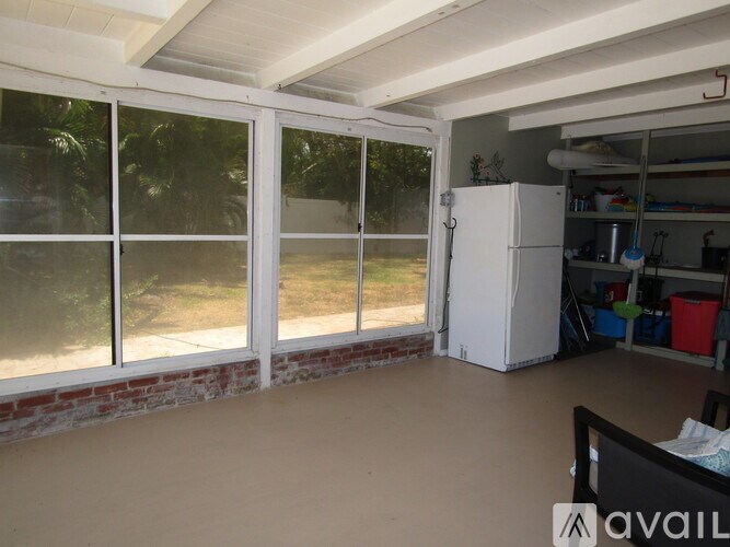 A kitchen with a refrigerator and a sliding glass door.
