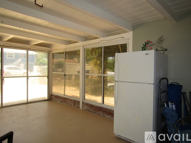 A white refrigerator is in a room with a window.