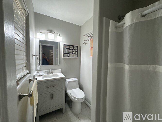 A bathroom with a toilet, sink, and shower.
