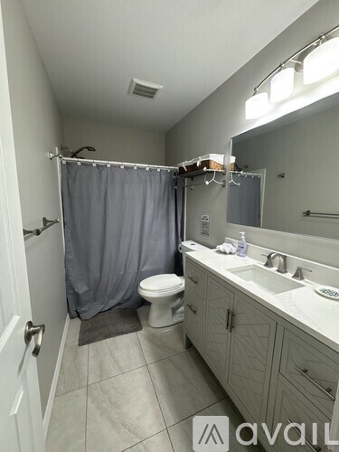 A bathroom with a toilet, sink, and shower.