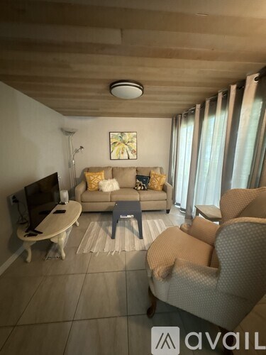 A living room with a couch, chair, and television.