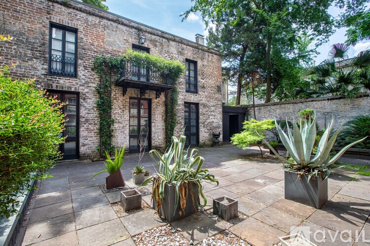 A patio area with a brick building and potted plants.