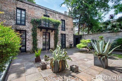 A patio area with a brick building and potted plants.