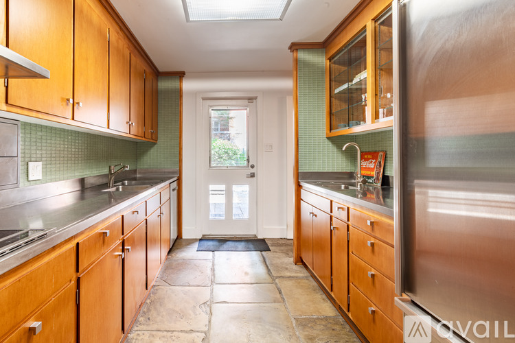 A kitchen with wooden cabinets and a green backsplash.