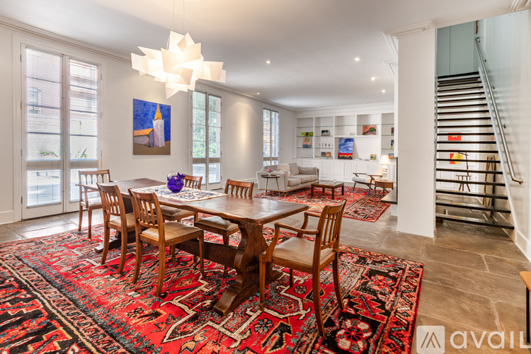 A dining room with a table and chairs and a rug.