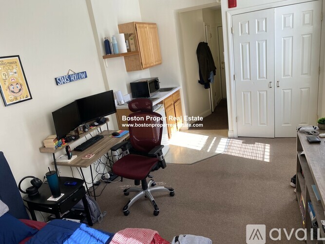 A room with a desk, chair, and a computer.