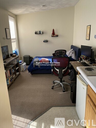 A bedroom with a bed, desk, and chair.