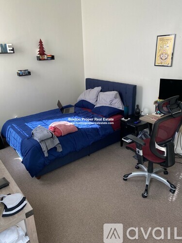 A bedroom with a bed, desk, and chair.