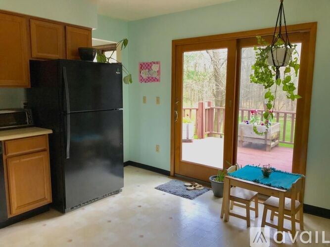 A kitchen with a black fridge and wooden cabinets.