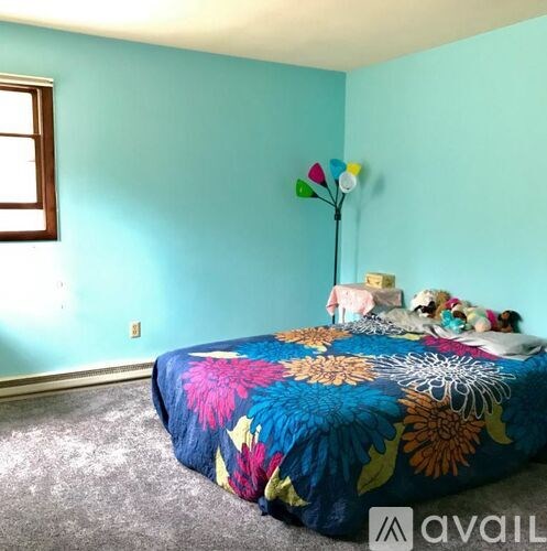 A room with a bed and a blue wall.