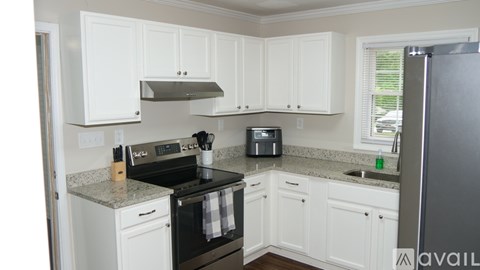 A kitchen with white cabinets and a black stove top.