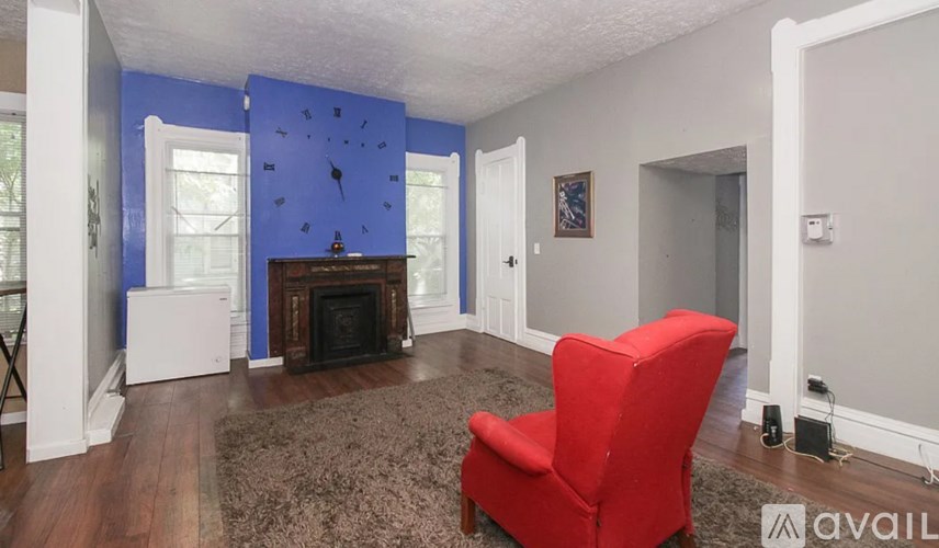 A red chair is in a room with blue walls.