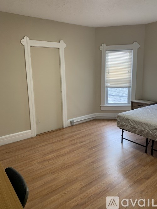 A room with a bed, chair, and window.