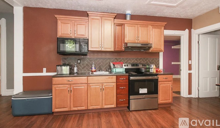 A kitchen with wooden cabinets and a microwave above the stove.
