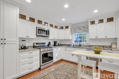 A kitchen with white cabinets and a central island.